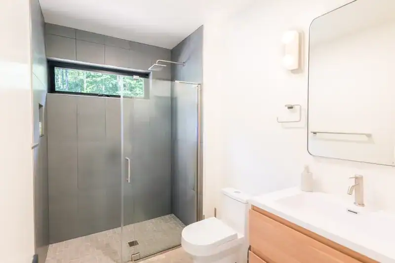 Bathroom with glass shower, vanity, and mirror