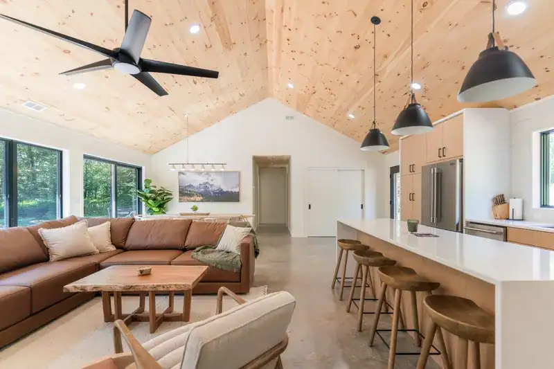 Open living, dining, and kitchen beneath vaulted pine ceilings