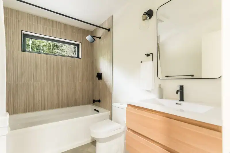 Bathroom with tub, vanity, and mirror