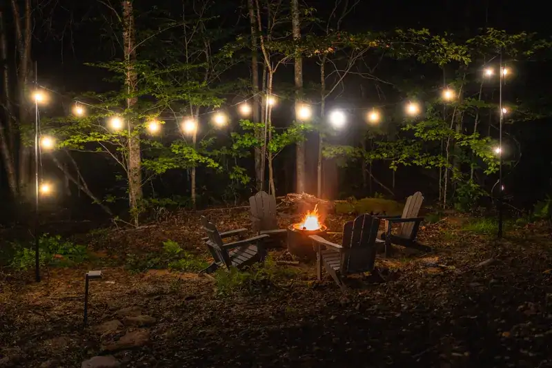 Fire pit glowing beneath string lights